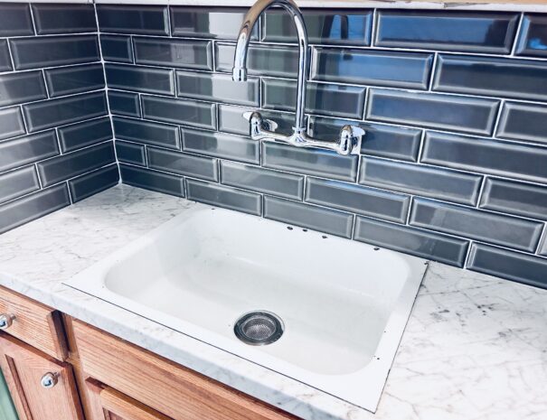 Large sink basin with pivoting faucet